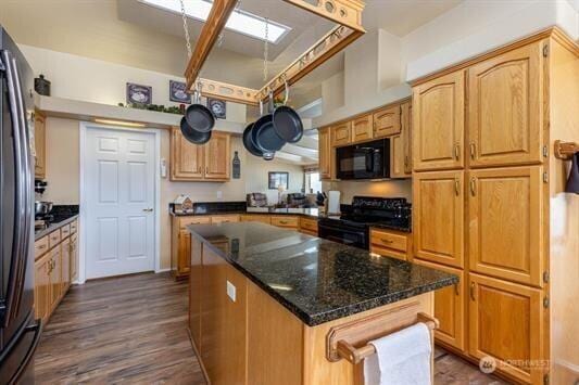 30350 Deer Meadows Rd E, Deer Meadows, WA 99122 - kitchen with range, black microwave, dark wood-style floors, dark stone countertops, and a center island