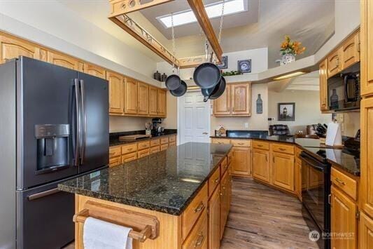 30350 Deer Meadows Rd E, Deer Meadows, WA 99122 - kitchen with black appliances, a skylight, a center island, dark wood-style floors, and dark stone countertops