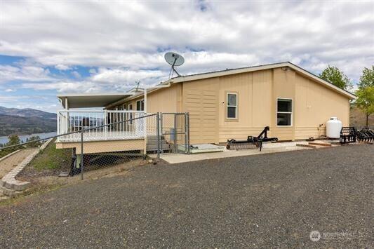 30350 Deer Meadows Rd E, Deer Meadows, WA 99122 - view of side of home featuring an attached carport and a wooden deck