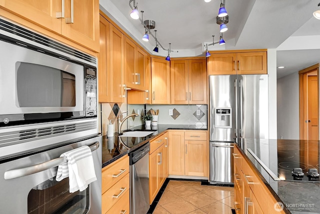 1605 5th Ave N Unit 402, Seattle, WA 98109 - kitchen with stainless steel appliances, decorative backsplash, light tile patterned floors, dark stone countertops, and a sink