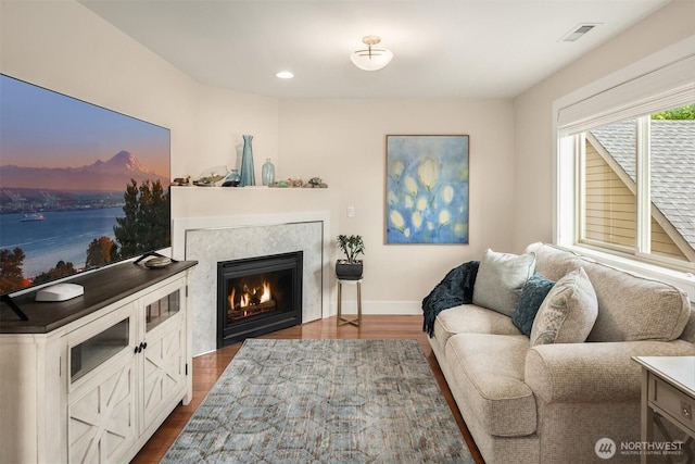 1032 76th Ave NE, Lake Stevens, WA 98258 - living area with dark wood-style floors, a warm lit fireplace, baseboards, and recessed lighting