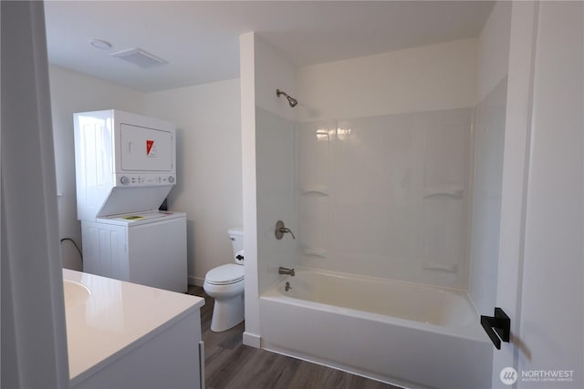 814 5th St Unit 8143, Steilacoom, WA 98388 - bathroom featuring stacked washer and clothes dryer, toilet, vanity, wood finished floors, and  shower combination