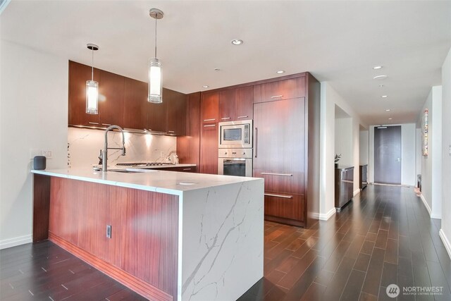 10700 NE 4th St Unit 1006, Bellevue, WA 98004 - kitchen featuring stainless steel appliances, dark wood finished floors, a peninsula, a sink, and modern cabinets