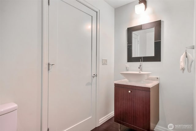 10700 NE 4th St Unit 1006, Bellevue, WA 98004 - bathroom featuring vanity, baseboards, toilet, and wood finished floors