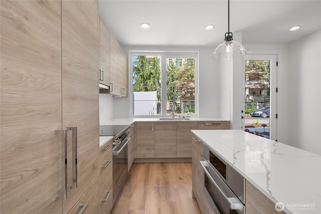 118E 2nd Ave S, Kirkland, WA 98033 - kitchen featuring high end stainless steel range, modern cabinets, a sink, light stone counters, and plenty of natural light