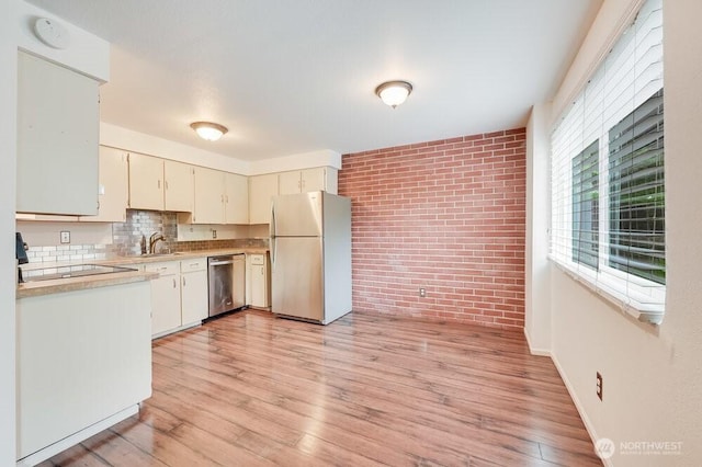 220 SW Clark St Unit B101, Issaquah, WA 98027 - kitchen featuring freestanding refrigerator, dishwasher, light countertops, brick wall, and a sink