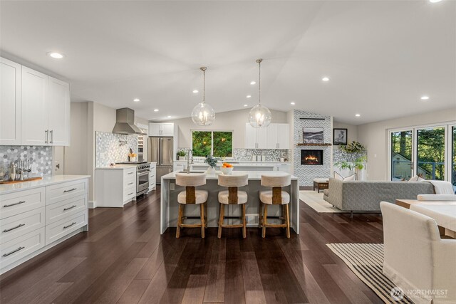7429 NE 129th St, Kirkland, WA 98034 - kitchen with wall chimney range hood, high quality appliances, open floor plan, decorative backsplash, and light countertops