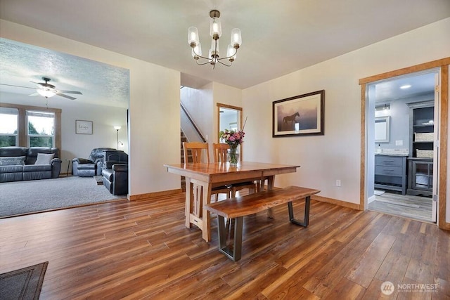 2217 200th St NE, Arlington, WA 98223 - dining area featuring wood finished floors, a ceiling fan, a chandelier, and baseboards