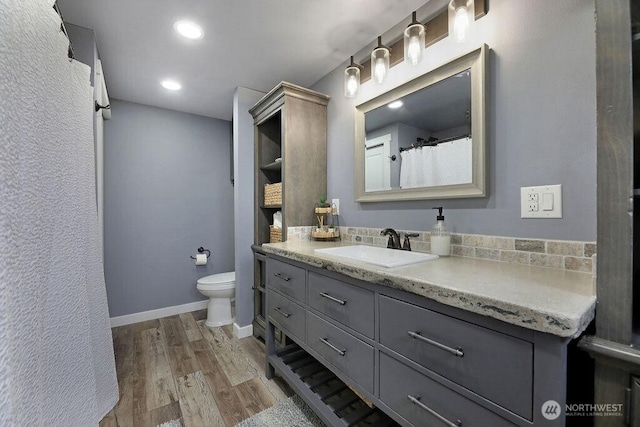 2217 200th St NE, Arlington, WA 98223 - bathroom featuring toilet, wood finished floors, vanity, recessed lighting, and baseboards
