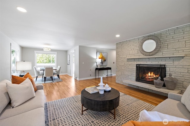 living room featuring a fireplace, wood finished floors, and baseboards