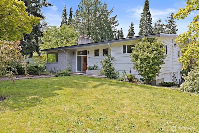 ranch-style home featuring a chimney, a front yard, and an attached garage