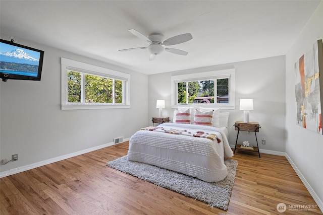bedroom featuring wood finished floors, baseboards, and ceiling fan