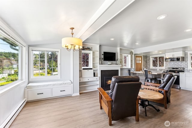 232 N Sunset Dr, Camano Island, WA 98282 - living room with a baseboard radiator, a glass covered fireplace, a chandelier, light wood-type flooring, and lofted ceiling