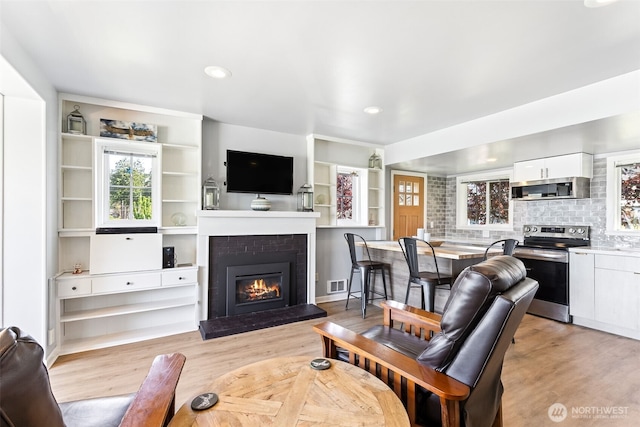 232 N Sunset Dr, Camano Island, WA 98282 - living room with light wood-style floors, a brick fireplace, and recessed lighting