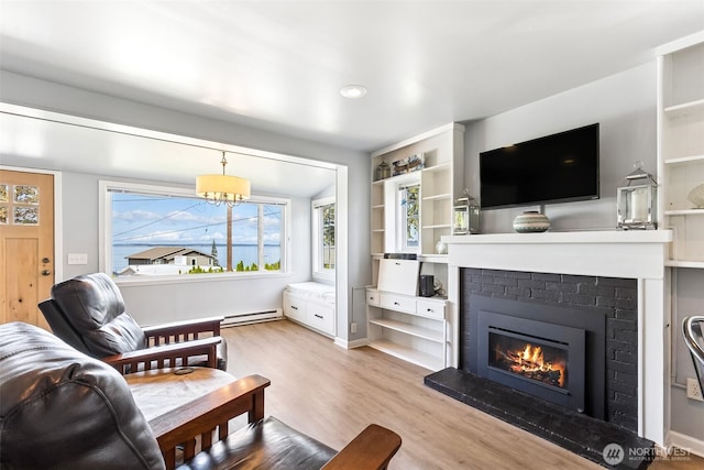 232 N Sunset Dr, Camano Island, WA 98282 - living area featuring a baseboard radiator, wood finished floors, a fireplace, and recessed lighting