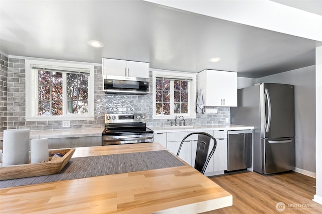 232 N Sunset Dr, Camano Island, WA 98282 - kitchen with appliances with stainless steel finishes, a sink, light countertops, white cabinetry, and tasteful backsplash