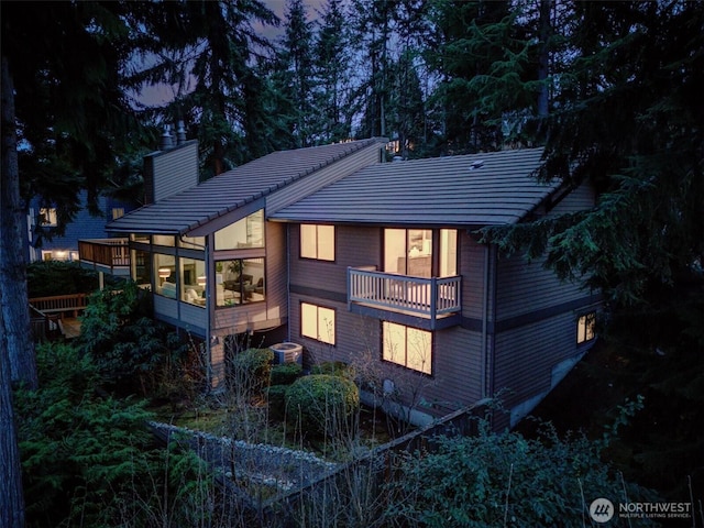 9340 Mercerwood Dr, Mercer Island, WA 98040 - back of property featuring a chimney, a balcony, central AC unit, a tile roof, and a sunroom