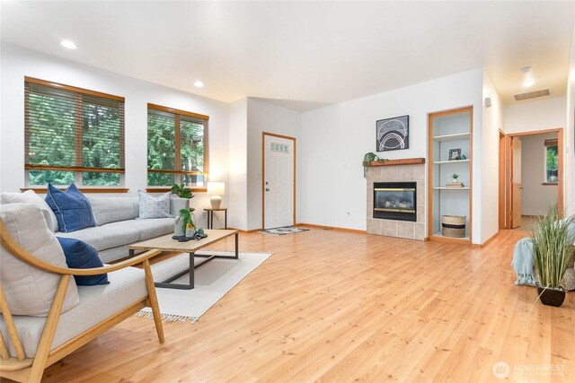 26 Inglewood Pl, Bellingham, WA 98229 - living area with healthy amount of natural light, wood finished floors, a tiled fireplace, recessed lighting, and built in features