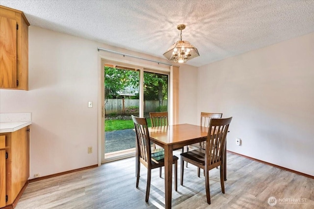 21918 83rd Ave W, Edmonds, WA 98026 - dining area featuring a chandelier, light wood-style flooring, a textured ceiling, and baseboards