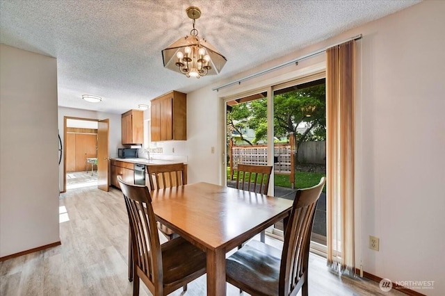 21918 83rd Ave W, Edmonds, WA 98026 - dining room featuring a textured ceiling, a chandelier, baseboards, and light wood-style flooring