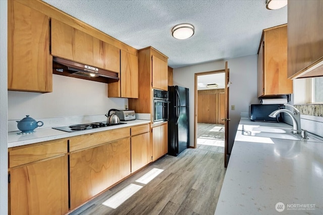 21918 83rd Ave W, Edmonds, WA 98026 - kitchen featuring black appliances, under cabinet range hood, light countertops, a sink, and a textured ceiling