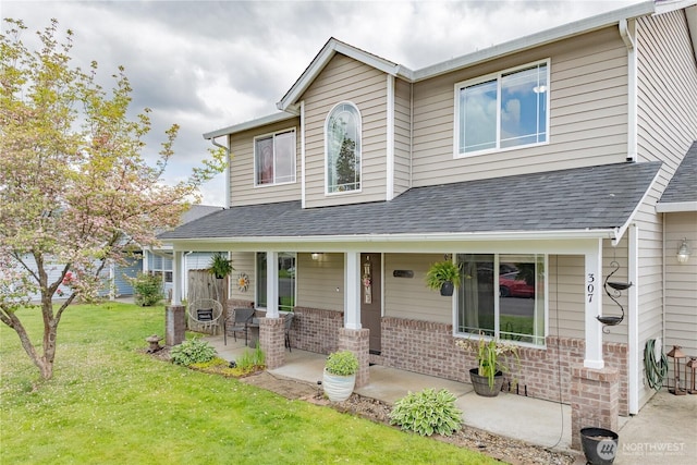307 E Wilson St, Yacolt, WA 98675 - view of front of house with a porch, brick siding, a front yard, and a shingled roof