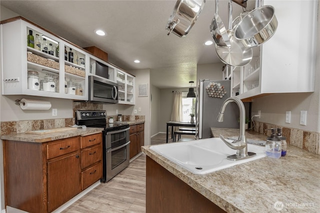 307 E Wilson St, Yacolt, WA 98675 - kitchen with stainless steel appliances, open shelves, a sink, light wood-style floors, and light countertops