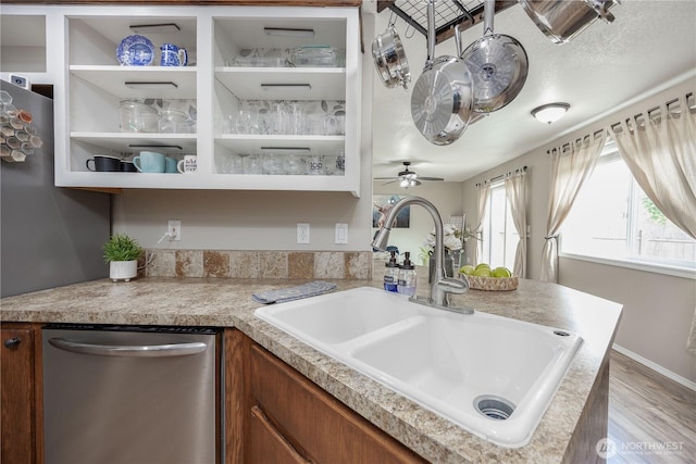 307 E Wilson St, Yacolt, WA 98675 - kitchen featuring stainless steel dishwasher, a sink, light countertops, wood finished floors, and brown cabinets