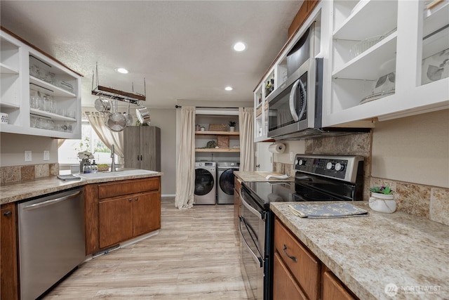 307 E Wilson St, Yacolt, WA 98675 - kitchen featuring stainless steel appliances, washer and dryer, open shelves, a sink, and light wood finished floors