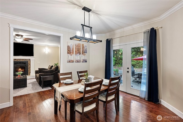 4565 Harper Hill Rd SE, Port Orchard, WA 98366 - dining space with ornamental molding, dark wood-type flooring, ceiling fan, a warm lit fireplace, and french doors