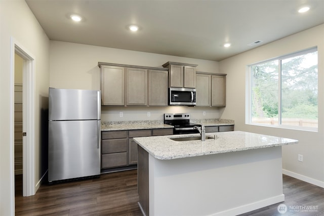 8507 13th Ave E, Tacoma, WA 98445 - kitchen with appliances with stainless steel finishes, a sink, dark wood finished floors, baseboards, and a center island with sink