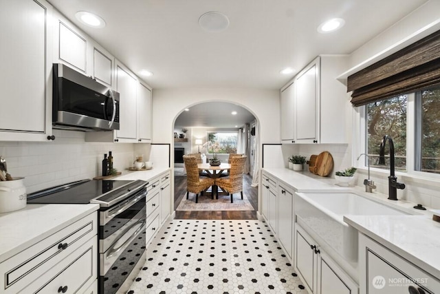 10220 NE Lafayette Ave, Bainbridge Island, WA 98110 - kitchen with appliances with stainless steel finishes, arched walkways, recessed lighting, light countertops, and white cabinets