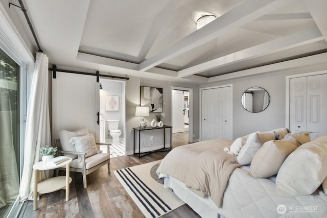 10220 NE Lafayette Ave, Bainbridge Island, WA 98110 - bedroom featuring a barn door, multiple closets, wood finished floors, and ensuite bathroom