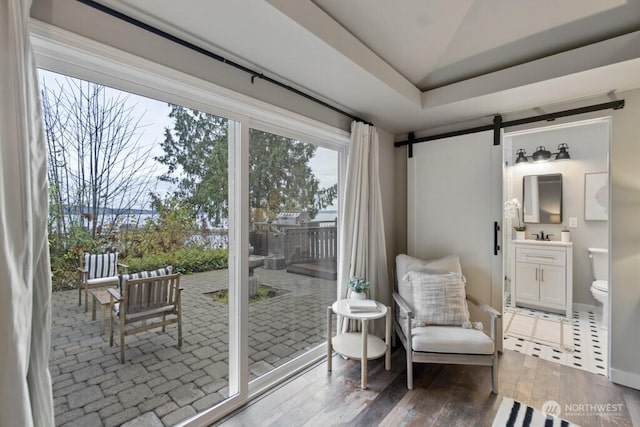 10220 NE Lafayette Ave, Bainbridge Island, WA 98110 - sitting room with wood finished floors, a barn door, lofted ceiling, and baseboards