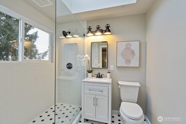 10220 NE Lafayette Ave, Bainbridge Island, WA 98110 - bathroom with plenty of natural light, a tile shower, vanity, and toilet