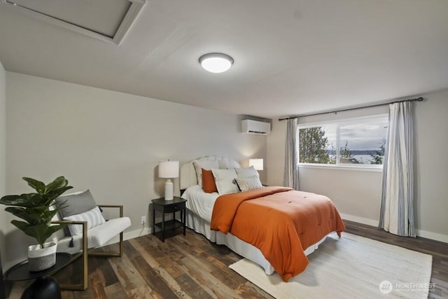 10220 NE Lafayette Ave, Bainbridge Island, WA 98110 - bedroom with a wall unit AC, wood finished floors, baseboards, and attic access