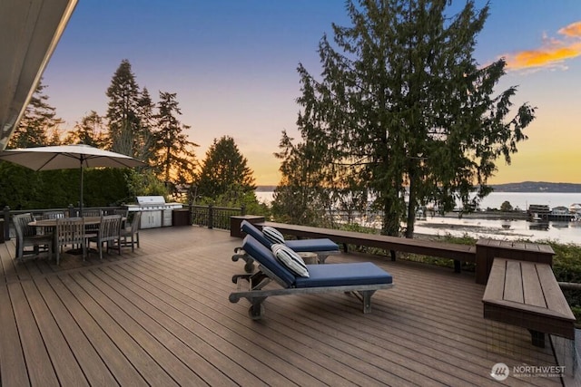 10220 NE Lafayette Ave, Bainbridge Island, WA 98110 - deck at dusk featuring a water view, an outdoor kitchen, and outdoor dining space