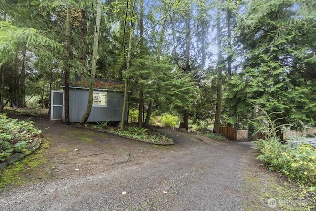 10220 NE Lafayette Ave, Bainbridge Island, WA 98110 - view of property exterior with a gate, an outbuilding, and dirt driveway