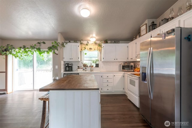 1707 Bonnie Ln, Camano Island, WA 98282 - kitchen featuring appliances with stainless steel finishes, a textured ceiling, white cabinetry, a center island, and tasteful backsplash