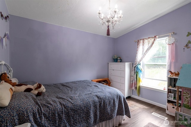 1707 Bonnie Ln, Camano Island, WA 98282 - bedroom with a chandelier, wood finished floors, and baseboards