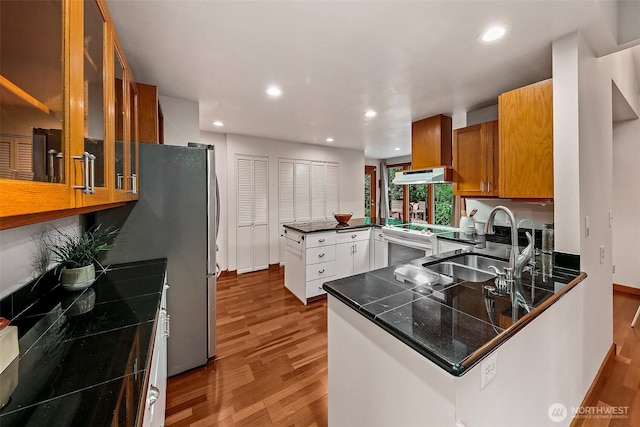 18527 Butternut Rd, Lynnwood, WA 98037 - kitchen featuring a peninsula, range, wood finished floors, brown cabinetry, and recessed lighting