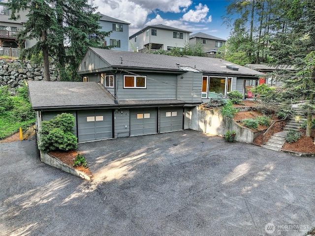 18527 Butternut Rd, Lynnwood, WA 98037 - rear view of house with driveway, an attached garage, and a residential view