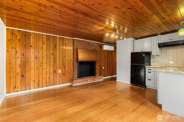 18527 Butternut Rd, Lynnwood, WA 98037 - unfurnished living room featuring a wall unit AC, light wood finished floors, wood ceiling, wooden walls, and a fireplace