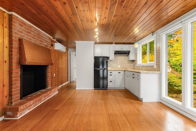 18527 Butternut Rd, Lynnwood, WA 98037 - kitchen with freestanding refrigerator, wooden ceiling, under cabinet range hood, a wall unit AC, and light wood-style flooring