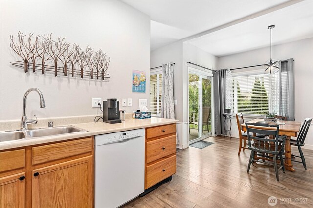 1305 Boon St Unit 112, Sumas, WA 98295 - kitchen with dishwasher, a sink, light wood-style floors, light countertops, and decorative light fixtures