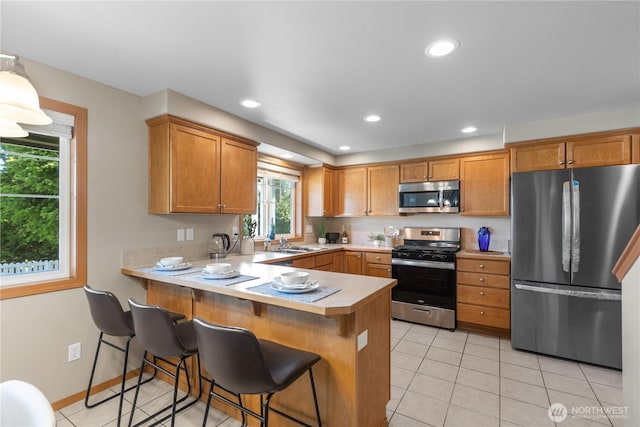 4507 Steves Aly, Mount Vernon, WA 98274 - kitchen with stainless steel appliances, light countertops, a sink, a peninsula, and light tile patterned floors