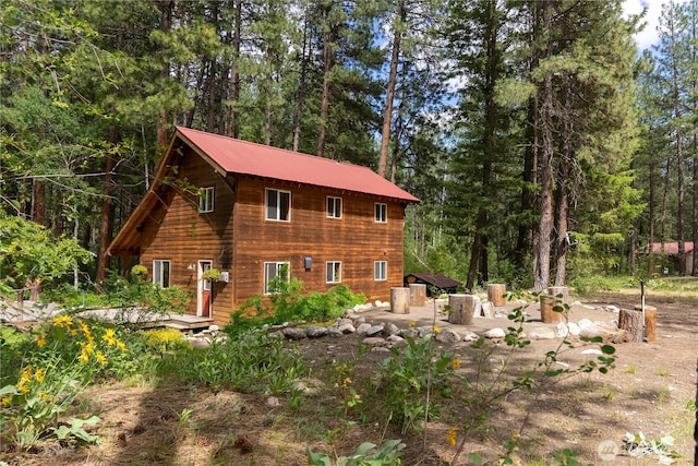 18 Deer Run Loop Rd, Winthrop, WA 98862 - rear view of house featuring a patio area, metal roof, and a wooded view