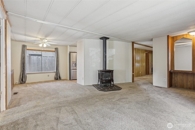 10132 228th Pl SE, Woodinville, WA 98077 - unfurnished living room featuring a wood stove, carpet floors, and a ceiling fan