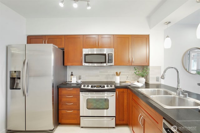 5450 Leary Ave NW Unit 442, Seattle, WA 98107 - kitchen featuring appliances with stainless steel finishes, dark countertops, decorative backsplash, and brown cabinets