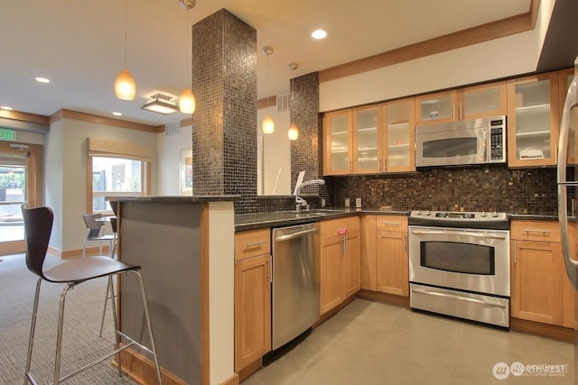 5450 Leary Ave NW Unit 442, Seattle, WA 98107 - kitchen featuring appliances with stainless steel finishes, a peninsula, decorative backsplash, a breakfast bar, and light tile patterned flooring